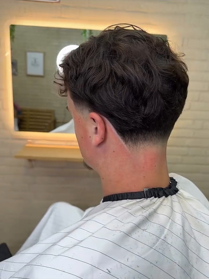 Achterkant van een kapsel met textuur en een strakke fade in de nek